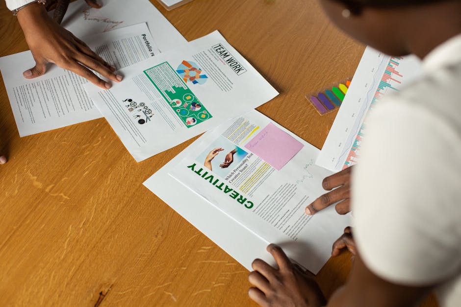 Top view of diverse team collaborating on documents, highlighting teamwork and creativity.